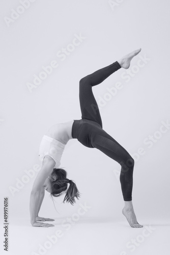 Black and white serie of photos of young fit woman practising yoga. Studio shot on white background.