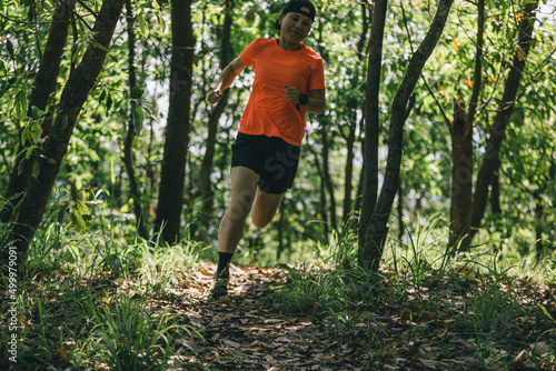 Woman runner running on forest trail