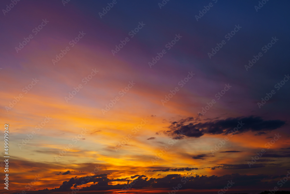 beautiful dramatic sunset sky, bright sunlight and dark silhouette of clouds as a background