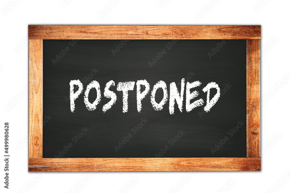 POSTPONED text written on wooden frame school blackboard. POSTPONED text written on wooden frame school blackboard.