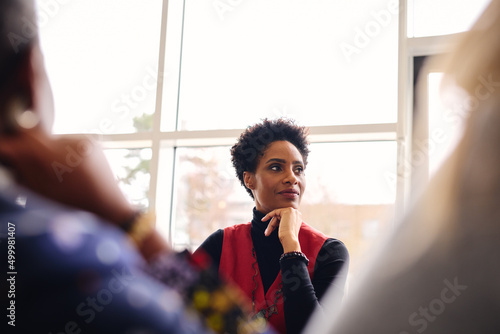 Foto Portrait of pensive mature black businesswoman listening with hand on chin in me