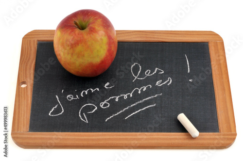 Fototapeta Naklejka Na Ścianę i Meble -  J'aime les pommes écrit sur une ardoise d'école sur laquelle sont posées une pomme et une craie