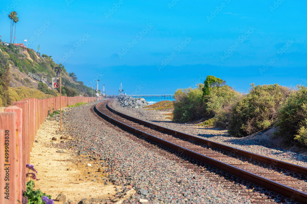 Train track in San Clemente, California with wooden posts barrier on the left