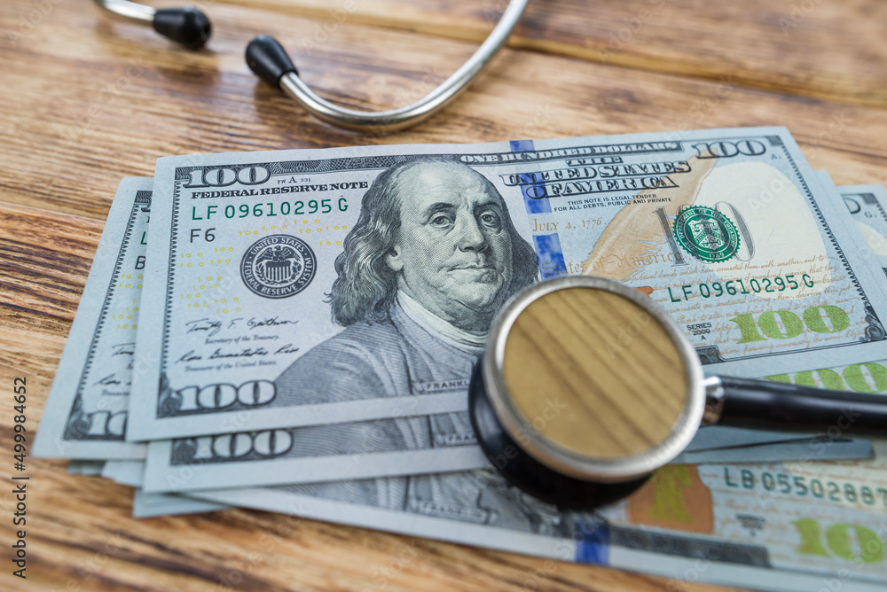 Hundred dollar bills and a stethoscope. Hundred dollar bills and a stethoscope.