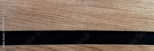 Drewniany front z czarną wąską linią. Zdjęcie panoramiczne.