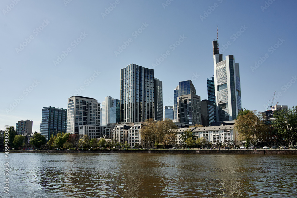 River Main and skyline in Frankfurt, Hesse, Germany. Office buildings and skyscrapers behind the water. Urban architecture.