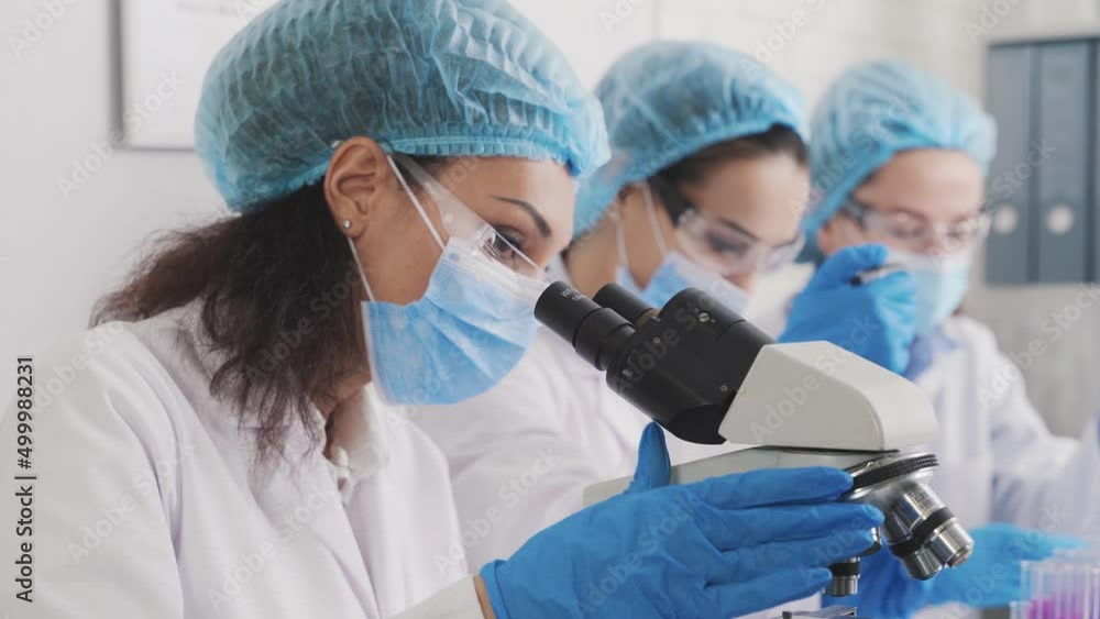 Medical Development Laboratory: portrait of a beautiful african american woman, Scientist Looking Under Microscope, People do Medicine, Biotechnology Research in Advanced Lab Medical Development Laboratory: portrait of a beautiful african american woman, Scientist Looking Under Microscope, People do Medicine, Biotechnology Research in Advanced Lab
