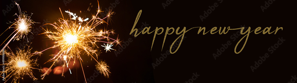 Happy New year 2023 background banner panorama - People hold sparkling sparkler in her hand at dark night
