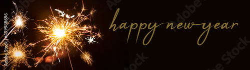 Happy New year 2023 background banner panorama - People hold sparkling sparkler in her hand at dark night