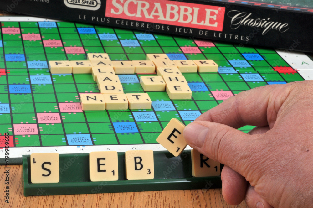 Main tenant une lettre de scrabble pour faire un mot Stock Photo Adobe Stock