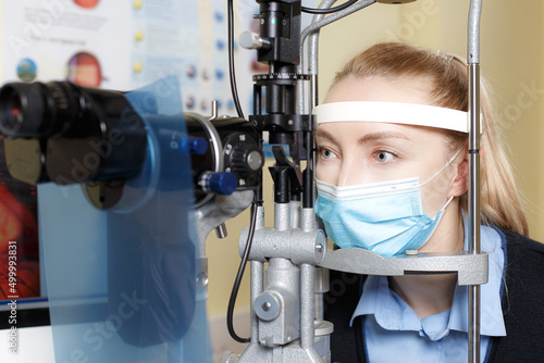 Fototapeta Naklejka Na Ścianę i Meble -  Caucasian blond female looking at slit lamp machine during medical check up in eye clime