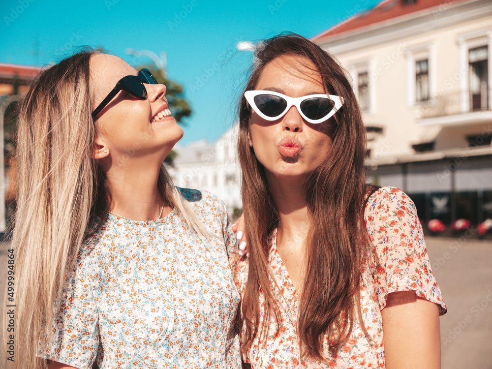 Two young beautiful smiling hipster female in trendy summer dresses.Sexy carefree women posing in the street. Positive pure models having fun at sunset, hugging and going crazy Two young beautiful smiling hipster female in trendy summer dresses.Sexy carefree women posing in the street. Positive pure models having fun at sunset, hugging and going crazy
