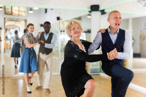 Mature woman learning to dance lindy hop with younger man