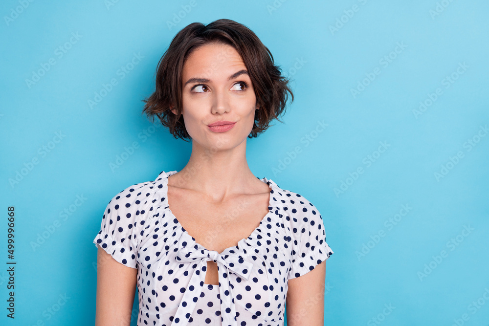Photo of nice young bob hairdo lady look promo wear dotted blouse isolated on blue color background Photo of nice young bob hairdo lady look promo wear dotted blouse isolated on blue color background