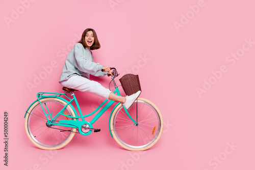 Fototapeta Naklejka Na Ścianę i Meble -  Full body profile side photo of young cheerful lady have fun playful hobby ride bike isolated over pink color background