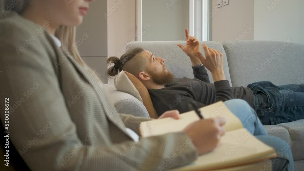 Young man talking to female psychologist during session. Young man talking to female psychologist during session.