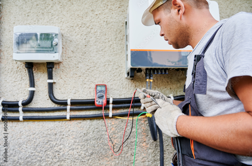 Man electrician installing solar panel system. Inspector in gloves