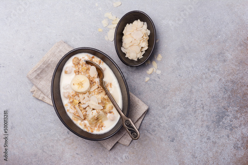 Healthy breakfast of granola with fresh banana, nuts and yogurt