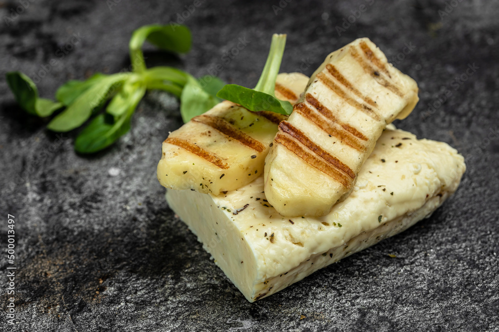 grilled slices of halloumi cheese with grill marks and mint. Cyprus squeaky cheese. Food recipe background. Close up grilled slices of halloumi cheese with grill marks and mint. Cyprus squeaky cheese. Food recipe background. Close up