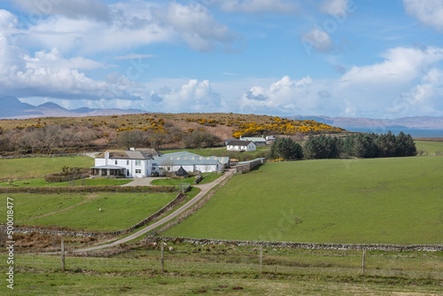 Bucolic landscape featuring a farmhouse surrounded by green pastures, farmland and the wild nature of Argyll and Bute region off the west coast of the country near Kilberry, Scotland, UK