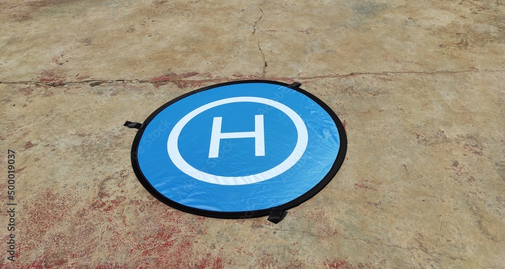 The landing pad for the drone is blue on a cement floor in the Cikancung area, Indonesia The landing pad for the drone is blue on a cement floor in the Cikancung area, Indonesia