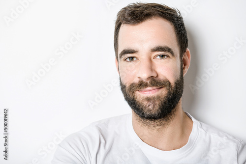 portrait of casual young man with beard on white background