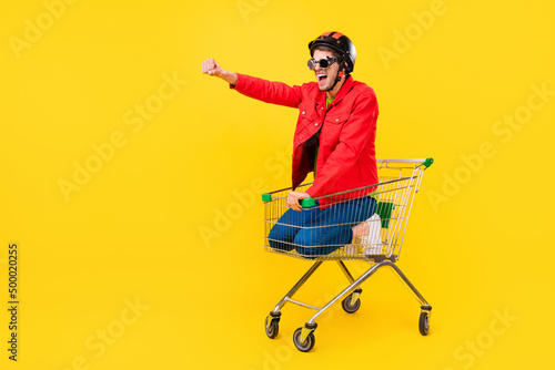 Fotobehang Full length body size view of attractive cheery guy inside cart having fun ridin