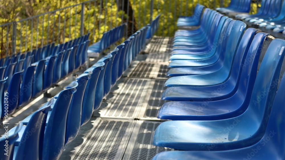 Fototapeta premium File di sedili blu di plastica in una tribuna temporanea