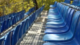 File di sedili blu di plastica in una tribuna temporanea 
