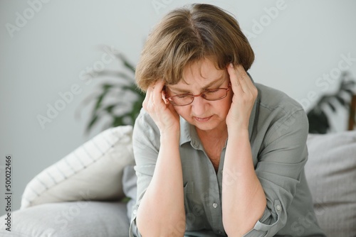 health care, pain, stress, age and people concept - face of senior woman suffering from headache photo