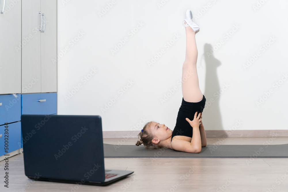 Obraz premium Little gymnast girl is training at home