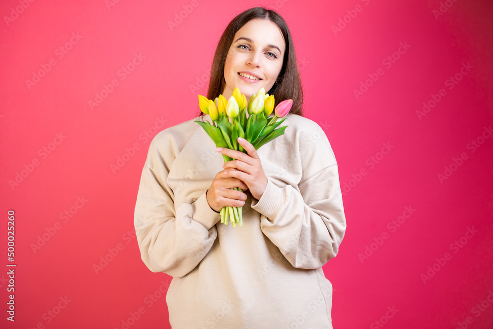 Happy young woman enjoy bouquet of tulips on pink background. Happy young woman enjoy bouquet of tulips on pink background.