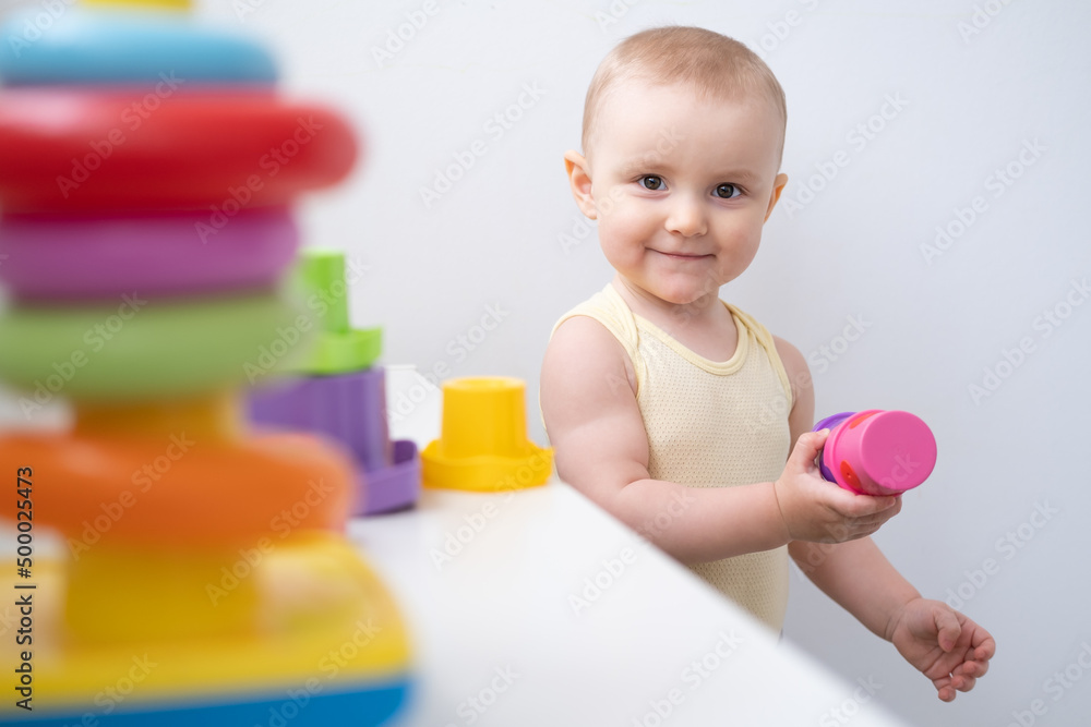 Cute kid girl playing in colorful plastic toys at home. Early childhood development Cute kid girl playing in colorful plastic toys at home. Early childhood development
