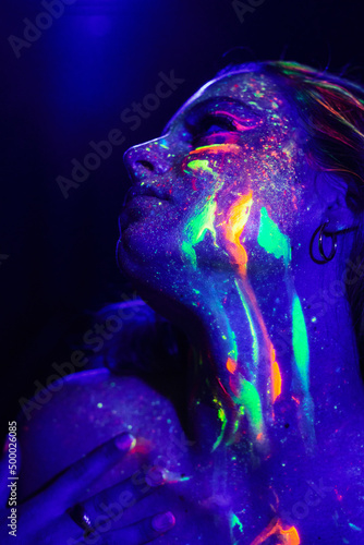 Charming woman with neon lights in darkness