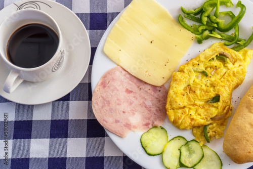 Fototapeta Naklejka Na Ścianę i Meble -  Top view of a breakfast omelette with bacon,cheese, bread and vegetables and cup of coffie