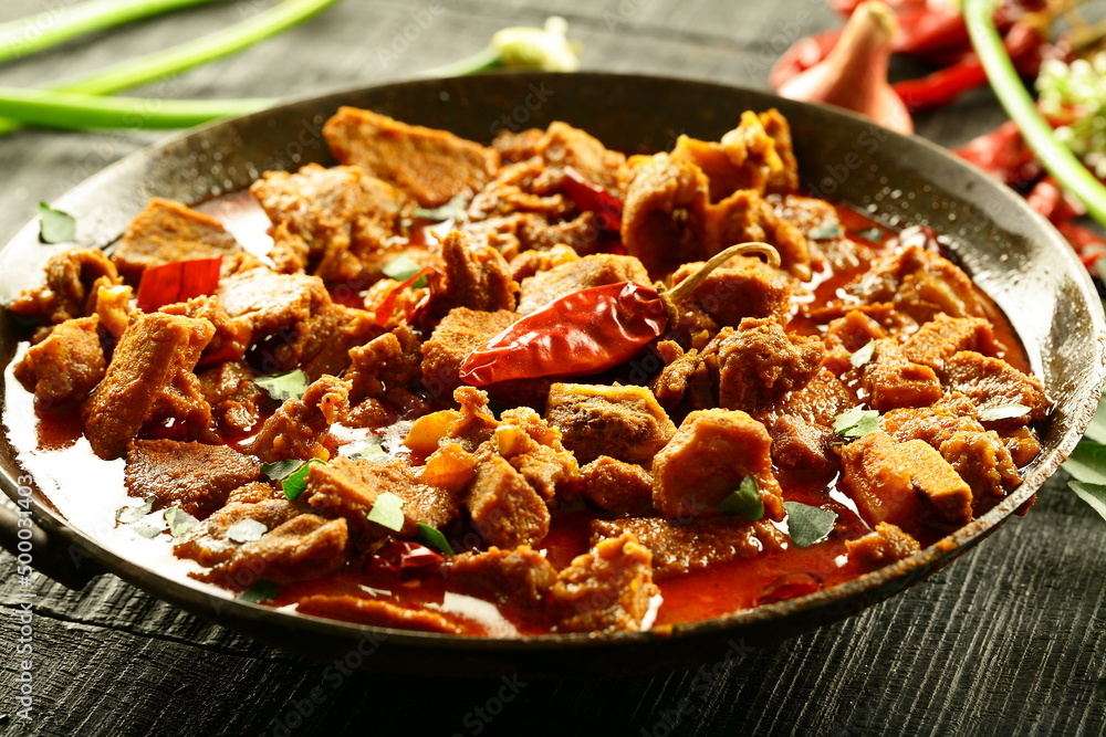 Homemade Indian beef curry roast cooked in iron skillet on wood fire. Traditional cokking concepts. Homemade Indian beef curry roast cooked in iron skillet on wood fire. Traditional cokking concepts.