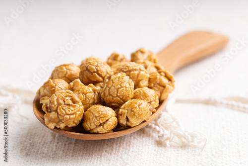 Caramel popcorn in wooden ladle photo