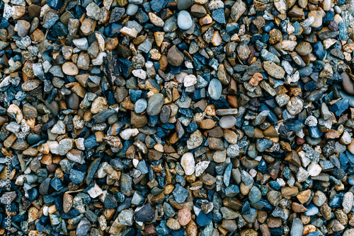 Mosaic sea pebbles background. Texture of small marine multi-colored pebbles.