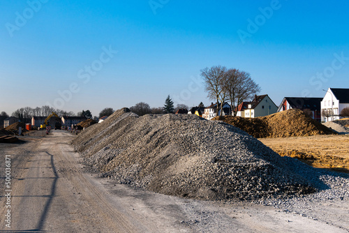 Piles of rubble and clay at a construction site. Blue sky.