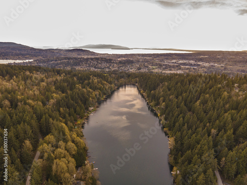 Scenic view of a calm lake surrounded by thick forest in Bellingham, Washington, USA photo