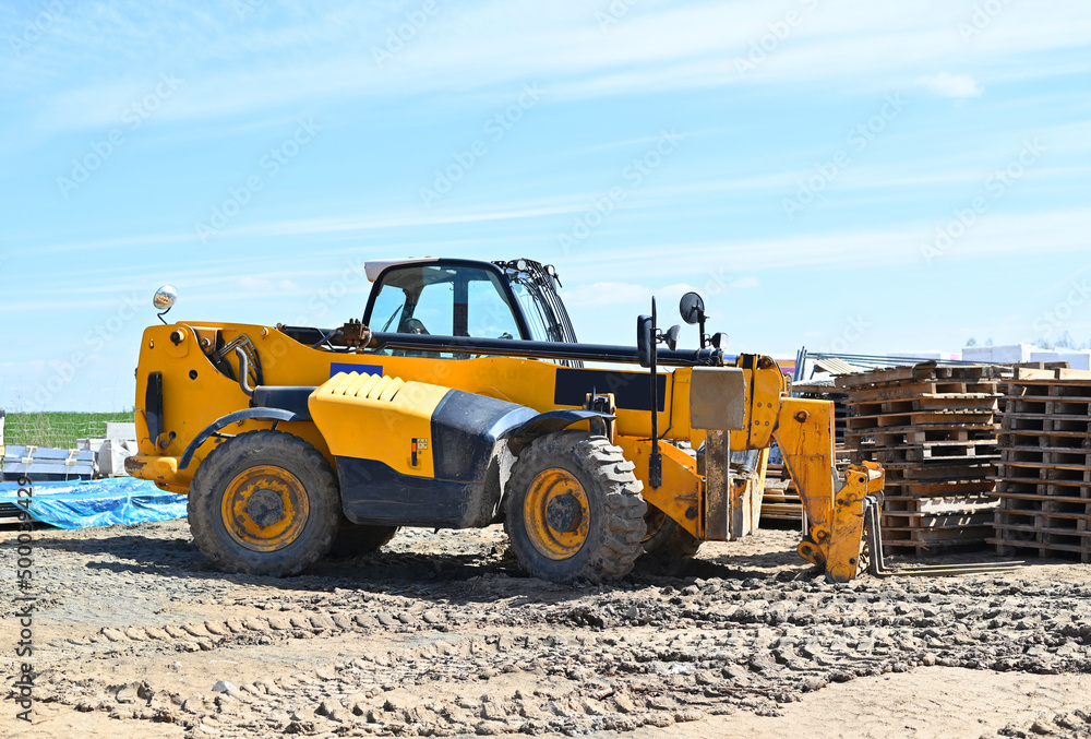 Yellow wheel loader machine transportation wooden pallet cargo at the construction site Yellow wheel loader machine transportation wooden pallet cargo at the construction site