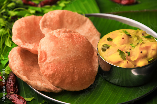 Photos south indian famous breakfast poori or puri with potato curry served in a plate