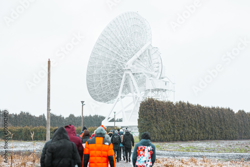 Canvastavla Group of people facing a large satellite antenna