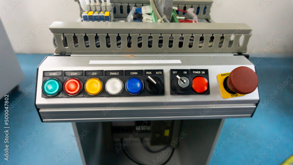 Front view of the push button on the industrial control panel of a