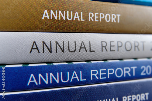 A stack of annual reports from public listed companies received by shareholders to review and evaluate the company business and financial performance of the previous year. Macro closeup view. photo