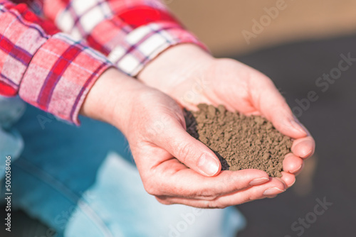 Handful of fertile soil, farm worker holding plowed dirt in hands