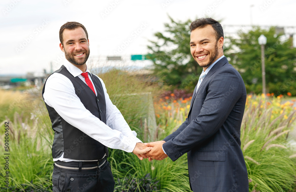 A Handsome gay male couple in the park on their wedding day A Handsome gay male couple in the park on their wedding day