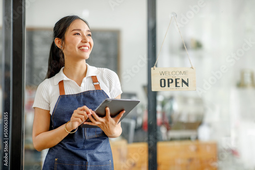 Canvas Print Young Asian businesswoman small business owner standing at cafeteria door entran
