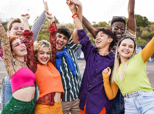 Group of diverse friends holding hands in the air while celebrate success
