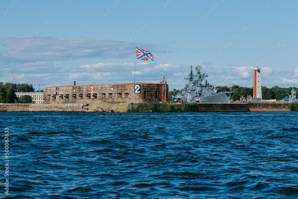 View from the water of the harbor and the parking of warships and submarines,the coastline of Kronstadt,the waters of the Gulf of Finland,the blue sea and waves.Russia,Kronstadt,31.07.2021